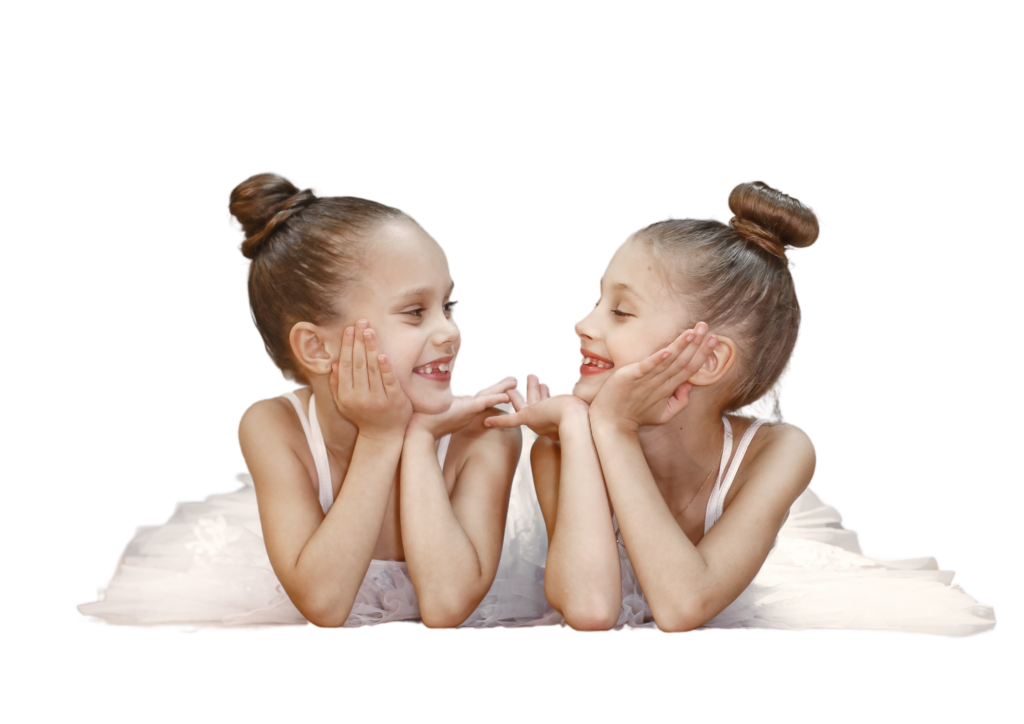 Young girls in tutus smiling at each other