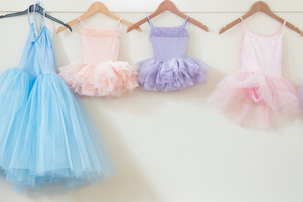 Young kids' tutus hanging on a wall